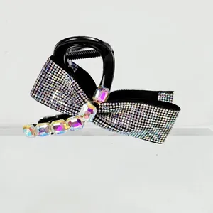 Detailed view of elegant bow hair claw with sparkling rhinestones and colorful emerald-cut gems