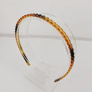 Detail of amber tortoiseshell headband featuring a premium woven resin texture design