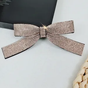 Close-up of a sparkling champagne crystal bow hair clip with luxury rhinestone inlay