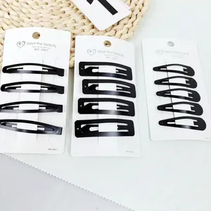 Close-up van matzwarte metalen BB-haarclips in verschillende vormen op displaykaarten