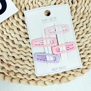 Detailansicht von 4 matten rosa und lila wellenförmigen Haarspangen auf Displaykarte
