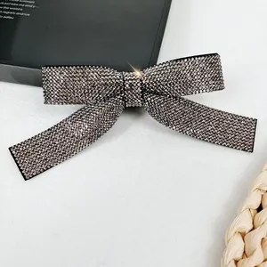 Close-up of elegant bow hair clip with gray pavé rhinestones and long ribbons