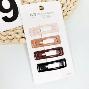 Close-up of four rectangular resin hair clips in earth tones on a white display card