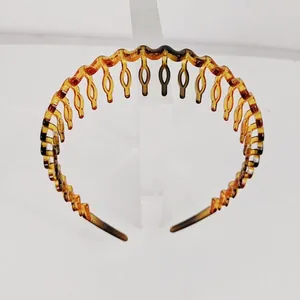 Detail view of amber tortoise shell headband with wavy teeth for secure hair grip