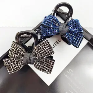 Detail van elegante zwarte haarklemmen met strikjes en sprankelende strass steentjes