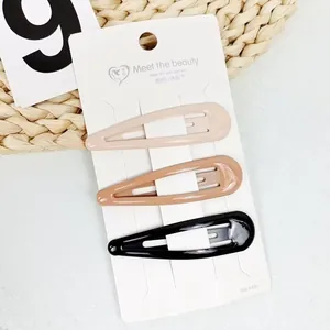 Three glossy star-shaped BB hair clips in cream, coffee, and black on a white display card