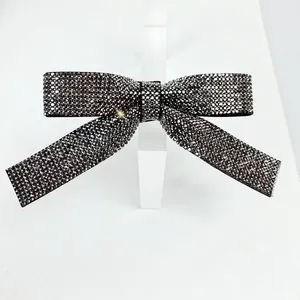 Detail of elegant black crystal bow hair clip with luxury full diamond sparkling texture