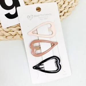 Three-piece heart shaped metal hair clips in beige, light brown, and black colors