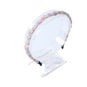 Diadema trenzada con cuentas en colores pastel suaves sobre un soporte transparente