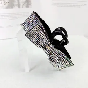 Detail of a vintage black bow hair claw clip with colorful sparkling rhinestones