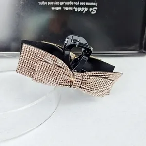 Detail of champagne rhinestone bow hair claw with sparkling crystals and black base