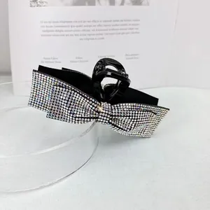 Macro detail of luxury bow hair claw clip with colorful aurora rhinestones inlay