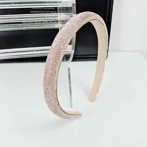 Vue macro de serre-tête luxe avec strass champagne scintillants sur support clair