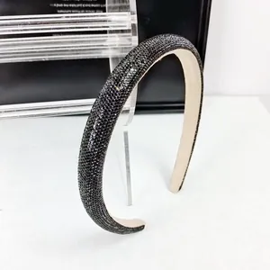 Gros plan sur un serre-tête en strass noirs avec une doublure intérieure en velours beige