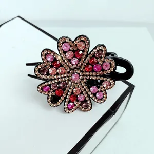 Detailed close-up of a floral hair claw clip featuring colorful sparkling rhinestones