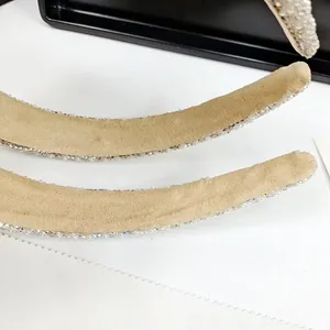 Detailed macro view of beige fabric headband with shimmering rhinestone trim craftsmanship