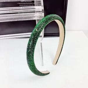 Vue détaillée d'un serre-tête de luxe avec strass verts et doublure douce