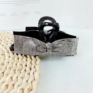 Elegant black hair claw clip featuring a large sparkling rhinestone butterfly bow design