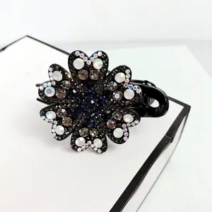 Detailed macro shot of floral hair claw clip featuring sparkling crystals and rhinestones