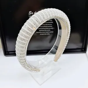 Close-up of wide padded headband with dense faux pearls and sparkling rhinestones
