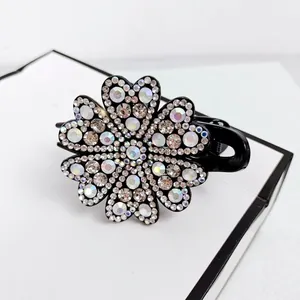 Macro detail of elegant hair claw clip featuring shimmering rhinestone flower pattern