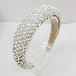 Détail du serre-tête rembourré blanc avec perles et strass sur support acrylique
