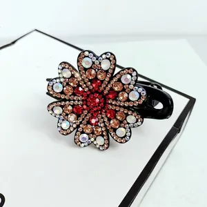 Close-up of elegant flower hair claw clip with colorful sparkling rhinestones on black base