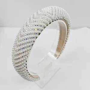 Détail d'un serre-tête large orné de rangées de perles blanches et strass brillants