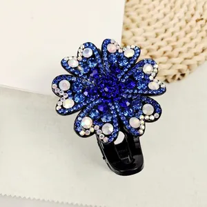 Detail of blue flower hair claw clip with shimmering rhinestones and black base