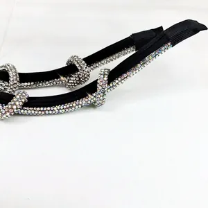 Detail of two narrow knot headbands with clear and multicolored rhinestones on black fabric