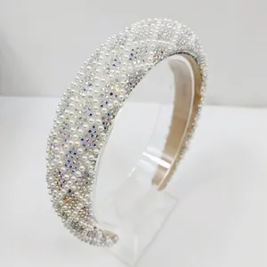 Détail d'un serre-tête large rembourré avec perles blanches et strass multicolores