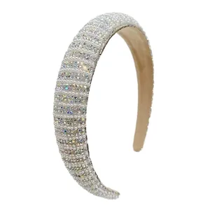 Detail of luxury padded headband with white pearls and sparkling rhinestones on beige fabric