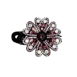 Macro shot of floral hair clip with pink rhinestones and a purple center gemstone