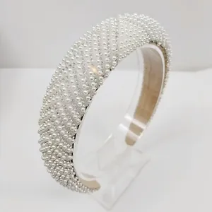 Gros plan du serre-tête large orné de perles denses et de rayures en strass brillants