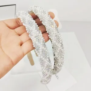 Close-up of dual headbands featuring luxurious white faux pearls and sparkling rhinestones