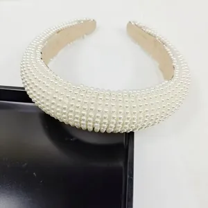 Gros plan de perles blanches et doublure en tissu beige antidérapant sur le bandeau