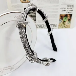 Detailed close-up of a black knotted headband with shimmering silver rhinestones