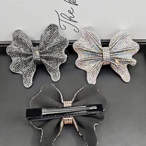 Elegant rhinestone bow hair clip set with black and iridescent crystals on metal duckbill base