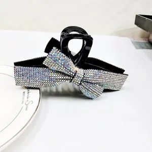 Vue détaillée de la grande pince à cheveux avec nœud en strass étincelant sur base noire