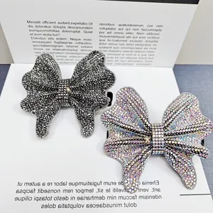 Elegant bow hair clips with shimmering rhinestones in dark grey and aurora colors