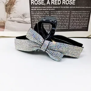 Détail d'une élégante pince à cheveux papillon avec strass colorés sur base noire