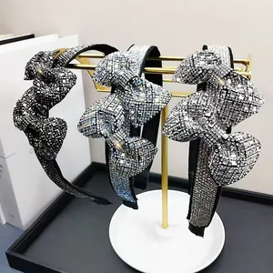 Close-up of three sparkling crystal bow headbands in silver, black and multi-color