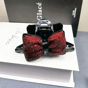 Gros plan détaillé d'une pince à cheveux noire avec deux nœuds élégants en strass rouges
