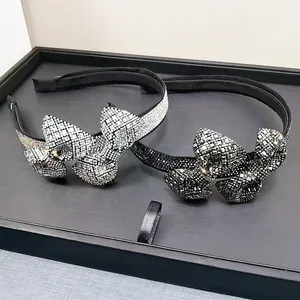 Detailed view of silver and dark grey sparkling crystal bow headbands on display