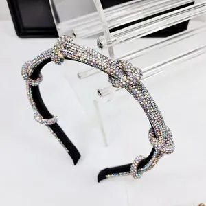 Macro view of black headband with colorful rhinestones and elegant knotted texture