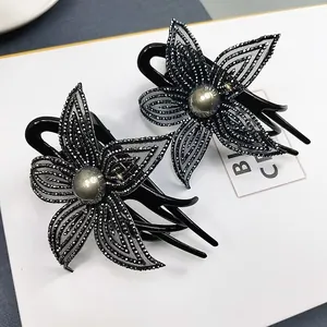 Dettaglio di mollette per capelli a fiori con strass, petali in rete e perle