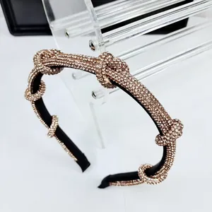 Detail of a knotted headband featuring shimmering champagne rhinestones on a black base