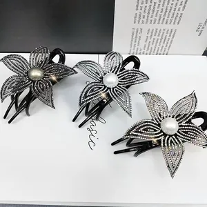 Dettaglio delle mollette per capelli a fiore con strass e perle in tre colori diversi