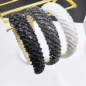 Close-up of three crystal padded headbands in black, grey, and iridescent white