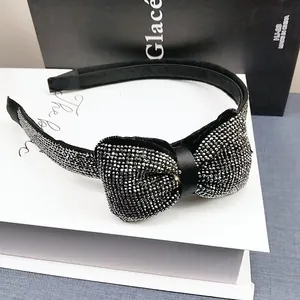 Détail d'une pince à cheveux noire élégante avec strass argentés brillants sur fond chic